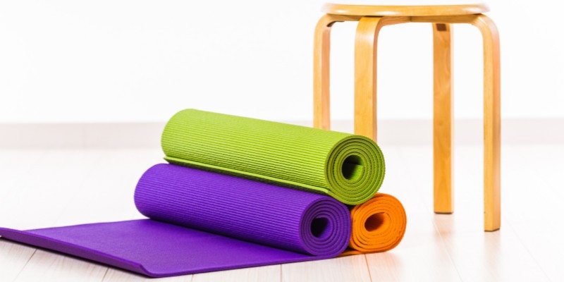 Yoga mats stacked next to a chair