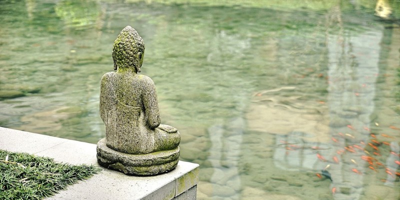 Buddha statue overlooking pond