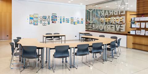 Tables and chairs set up in a horseshoe-shape facing the front of the room