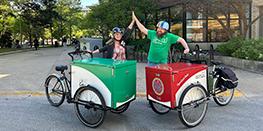 Two librarians high fiving while with Oak Park's two book bikes