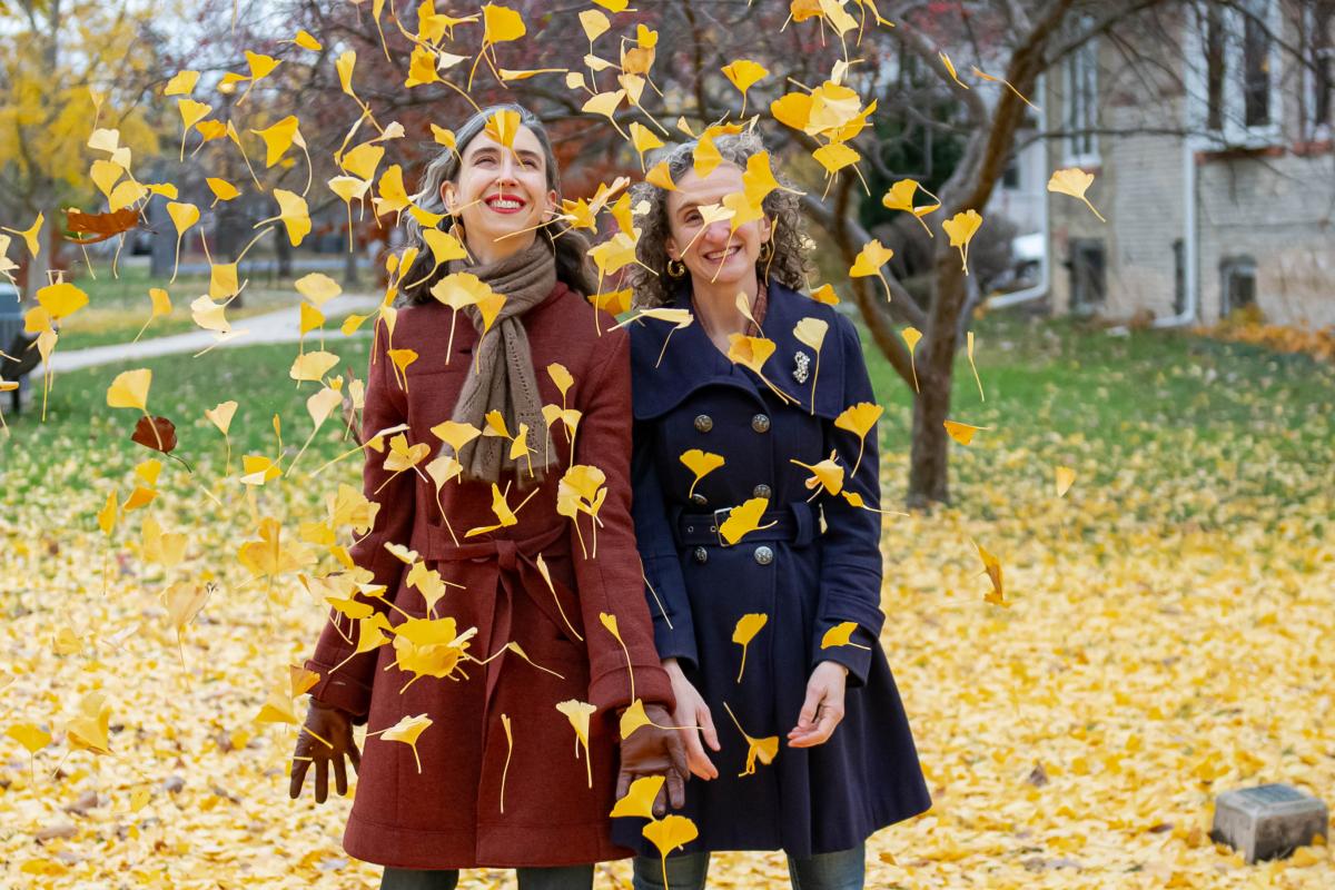 Photo of authors Kathleen and Beth Rooney outside surrounded by leaves
