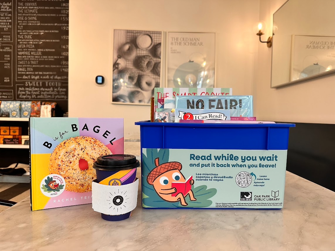 Bin of books with a cup of coffee inside a bagel shop